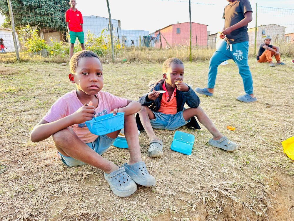 Children eating a meal at a UGM outreach event